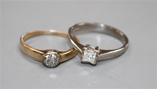 A modern 18ct gold and princess cut solitaire diamond ring and a 585 and solitaire diamond ring, sizes M & L, gross 2.7 grams & 2 g
